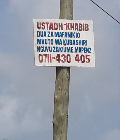 An advertisment posted on a wooden electical pole for a healer who is concerned with sexual  performance (nguvu za kiume) among others.
