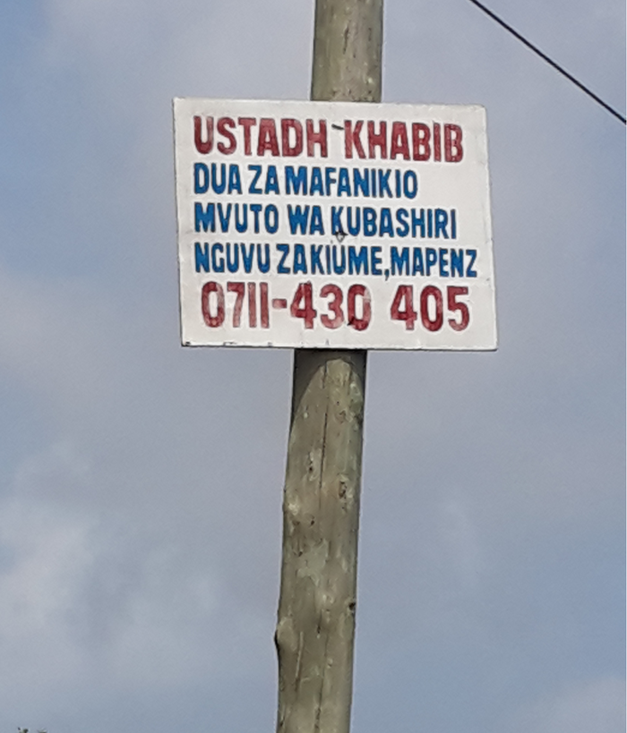 An advertisment posted on a wooden electical pole for a healer who is concerned with sexual  performance (nguvu za kiume) among others.