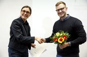 Simon Lübke erhält den Preis für die beste Masterarbeit von Prof. Dr. Maria Löblich.