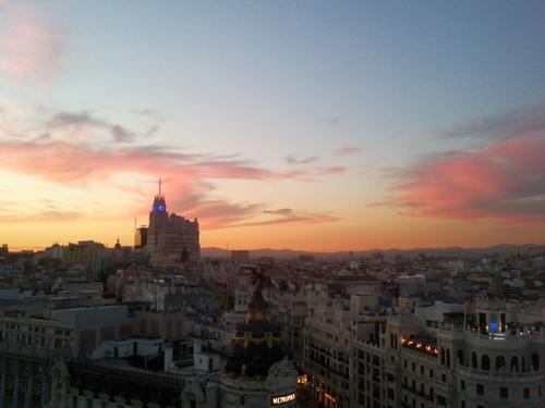 Blick über die Gran Vía bei Sonnenuntergang (das Gebäude mit Uhrenturm ist das "Edificio Telefónica", die Zentrale der spanischen Telefongesellschaft und der erste Wolkenkratzer von Madrid)